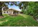 A beautiful backyard with a well-manicured lawn, patio, mature trees, and landscaping at 9049 Saint Andrews Way, Mount Dora, FL 32757