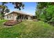 This backyard features a beautiful manicured lawn, mature trees, patio, and landscaping at 9049 Saint Andrews Way, Mount Dora, FL 32757