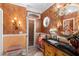 Elegant bathroom with a decorative mirror and stone countertops, offering a spa-like retreat at 9049 Saint Andrews Way, Mount Dora, FL 32757