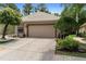 Charming home featuring a two-car garage with a tile roof and well-maintained landscaping at 9049 Saint Andrews Way, Mount Dora, FL 32757