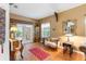 Cozy living area featuring hardwood floors and access to the outdoor patio through glass doors at 9049 Saint Andrews Way, Mount Dora, FL 32757
