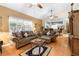 Comfortable living room with hardwood flooring, ceiling fan, and open layout to the kitchen at 9049 Saint Andrews Way, Mount Dora, FL 32757