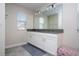 Bathroom with a double sink vanity and a large mirror at 10038 Verse Aly, Winter Garden, FL 34787