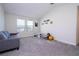 Bright room with a gray couch, cartoon wall decor, and natural light from two large windows at 10038 Verse Aly, Winter Garden, FL 34787