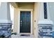 Charming front entrance featuring a dark door, stone accents, and stylish address numbers at 10038 Verse Aly, Winter Garden, FL 34787