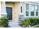Inviting front entrance with a dark door, stone accents, and decorative plants at 10038 Verse Aly, Winter Garden, FL 34787