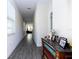 Bright hallway with wood-look tile, leading to a sunlit living area and decorated with stylish console table at 10038 Verse Aly, Winter Garden, FL 34787
