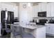 Bright kitchen includes a black fridge, and a central island with bar stool seating at 10038 Verse Aly, Winter Garden, FL 34787