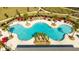 Aerial view of a uniquely shaped resort-style pool with ample seating, red umbrellas, and lush palm trees at 10038 Verse Aly, Winter Garden, FL 34787