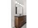 Modern bathroom vanity with dark countertop and globe lighting at 11019 Kentmere Ct, Windermere, FL 34786