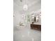 Bright primary bathroom with white marble floors, modern tub, and stylish lighting fixtures at 11019 Kentmere Ct, Windermere, FL 34786