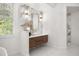 Bathroom vanity with white marble backsplash, wooden cabinets, and modern gold lighting fixtures at 11019 Kentmere Ct, Windermere, FL 34786