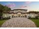 Imposing two-story home featuring a tile roof, arched windows, and a paver driveway at 11019 Kentmere Ct, Windermere, FL 34786