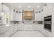 Gourmet kitchen featuring custom white cabinetry, modern appliances, and marble countertops at 11019 Kentmere Ct, Windermere, FL 34786