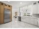 Bright kitchen featuring stainless steel appliances, white cabinetry, and marble flooring at 11019 Kentmere Ct, Windermere, FL 34786
