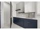 Stylish laundry room with navy cabinets, white countertops, and modern backsplash at 11019 Kentmere Ct, Windermere, FL 34786