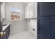 Laundry room boasts navy and white cabinets, marble floors, and a window with natural light at 11019 Kentmere Ct, Windermere, FL 34786