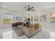 Bright living room features white walls, marble floors, a ceiling fan, and natural light from the windows at 11019 Kentmere Ct, Windermere, FL 34786