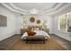 Comfortable main bedroom featuring a tray ceiling, hardwood floors, and natural light at 11019 Kentmere Ct, Windermere, FL 34786