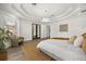 Spacious main bedroom featuring a modern tray ceiling, a crystal chandelier, and a cozy seating area at 11019 Kentmere Ct, Windermere, FL 34786