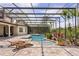 Inviting screened pool and spa, surrounded by colorful landscaping and brick pavers at 11019 Kentmere Ct, Windermere, FL 34786