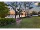 Waterfront backyard featuring lush green lawn and beautiful lake view at sunset at 11632 Lake Willis Dr, Orlando, FL 32821
