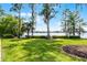 Beautiful lake view from lush green backyard with mature trees and landscaping at 11632 Lake Willis Dr, Orlando, FL 32821