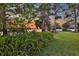 A lush backyard with mature trees leads to a serene lake at sunset at 11632 Lake Willis Dr, Orlando, FL 32821