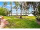 Backyard featuring a well-manicured lawn and mature trees, bordering a serene lake at 11632 Lake Willis Dr, Orlando, FL 32821