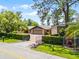 Home exterior with brick driveway, metal building, and well-maintained landscaping at 11632 Lake Willis Dr, Orlando, FL 32821