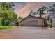 Brick home with a wide driveway, surrounded by mature trees, landscaped for curb appeal at 11632 Lake Willis Dr, Orlando, FL 32821