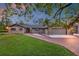 Charming home with a brick driveway, lush green lawn, and mature trees, bathed in twilight at 11632 Lake Willis Dr, Orlando, FL 32821