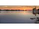 Scenic view of a tranquil lake with buildings on the horizon at sunset at 11632 Lake Willis Dr, Orlando, FL 32821