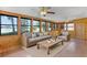 Inviting sunroom with wood paneled walls and multiple windows overlooking the lake at 11632 Lake Willis Dr, Orlando, FL 32821