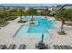 A multi-tiered community pool is surrounded by lounge chairs and tables with umbrellas at 12127 Sonnet Ave, Orlando, FL 32832