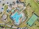 Aerial view of a community pool with a unique shape, a clubhouse, tennis court, and playground at 12127 Sonnet Ave, Orlando, FL 32832