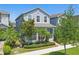 Charming two-story home with manicured lawn, lush landscaping, and mature trees at 12127 Sonnet Ave, Orlando, FL 32832