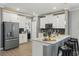 Well-lit kitchen with white cabinetry, stainless steel refrigerator, and modern bar seating at 12127 Sonnet Ave, Orlando, FL 32832