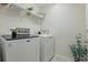 Functional laundry room with washer, dryer, and shelving for storage and organization at 12127 Sonnet Ave, Orlando, FL 32832