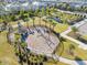 A community playground with slides and a sand pit is fenced in and surrounded by palm trees at 12127 Sonnet Ave, Orlando, FL 32832