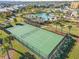 Aerial view showcases a community tennis court surrounded by lush greenery and palm trees at 12127 Sonnet Ave, Orlando, FL 32832