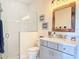Bright bathroom featuring a walk-in shower with white subway tiles, rustic mirror, and a gray vanity at 1271 Thoroughbred Trl, Sanford, FL 32771