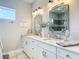 Bright bathroom featuring double vanity, marble countertops, decorative mirrors, and modern fixtures for a spa-like experience at 1271 Thoroughbred Trl, Sanford, FL 32771