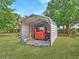 Metal carport with a small tractor and equipment, surrounded by green grass at 1271 Thoroughbred Trl, Sanford, FL 32771