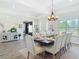 Elegant dining room with wood floors, large windows and a stylish chandelier create an inviting atmosphere at 1271 Thoroughbred Trl, Sanford, FL 32771