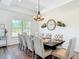Bright dining room featuring a chandelier and decorative clock adjacent to the dining table at 1271 Thoroughbred Trl, Sanford, FL 32771