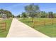 Long, paved driveway leading to the house, surrounded by green lawns and a wooden fence at 1271 Thoroughbred Trl, Sanford, FL 32771