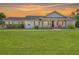 Charming home with shuttered windows, front porch with wooden columns and a large lawn at sunset at 1271 Thoroughbred Trl, Sanford, FL 32771