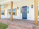 Inviting front porch with a rocking chair, wooden pillars, and a wreath on the blue front door at 1271 Thoroughbred Trl, Sanford, FL 32771