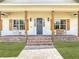 Charming front porch with brick steps, wooden columns, and a cozy bench, perfect for relaxing at 1271 Thoroughbred Trl, Sanford, FL 32771